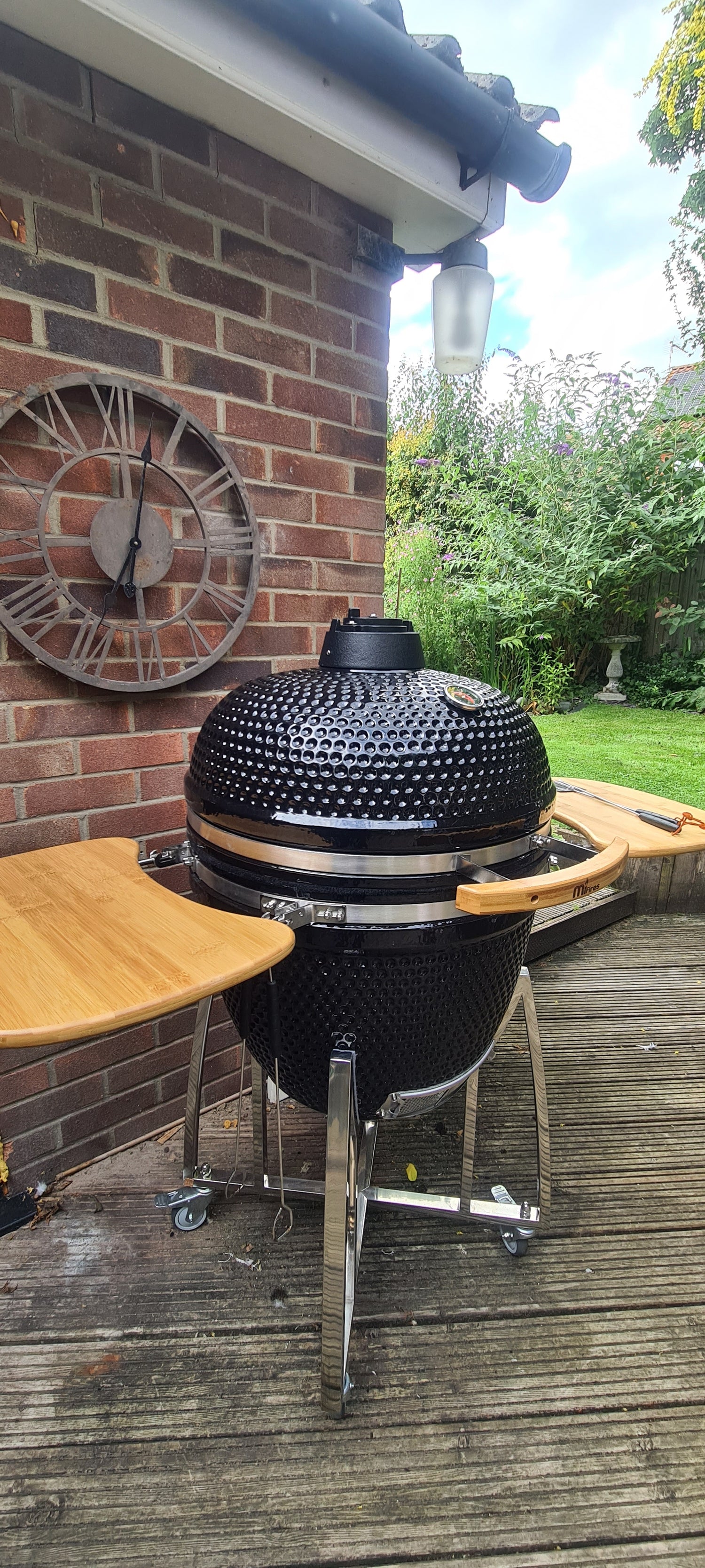 A black 23" Kamado grill with chrome stand.